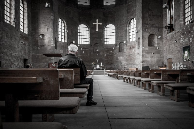hombre orando en la iglesia